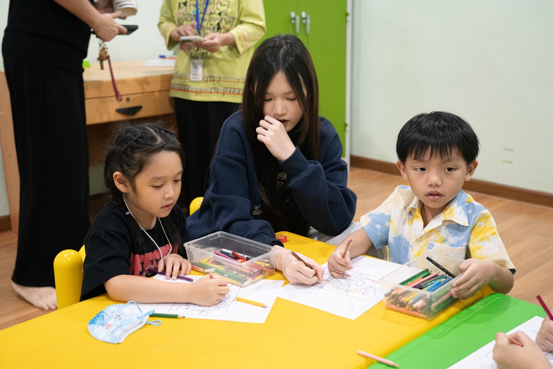children-drawing-with-a-teacher-at-a-table-9fi8p2qopno