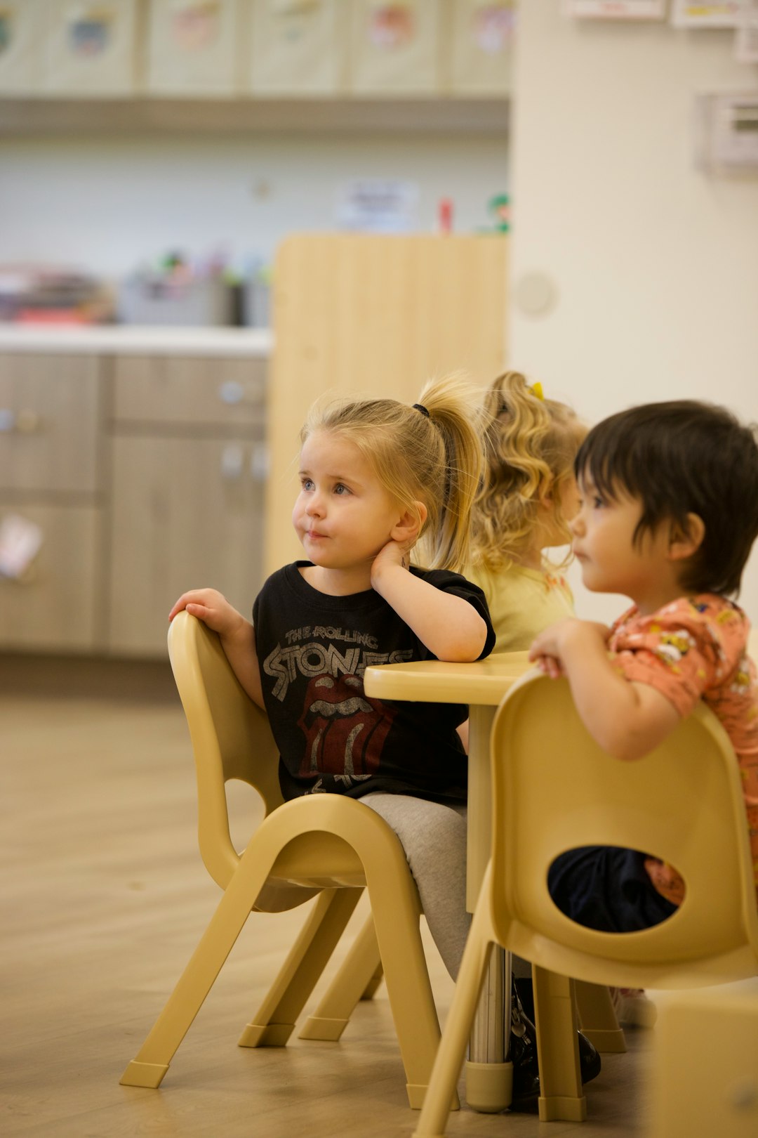 young-children-sitting-at-a-table-in-a-classroom-lgpgzbvmd-o